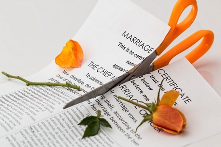Scissors cutting through marriage certificate